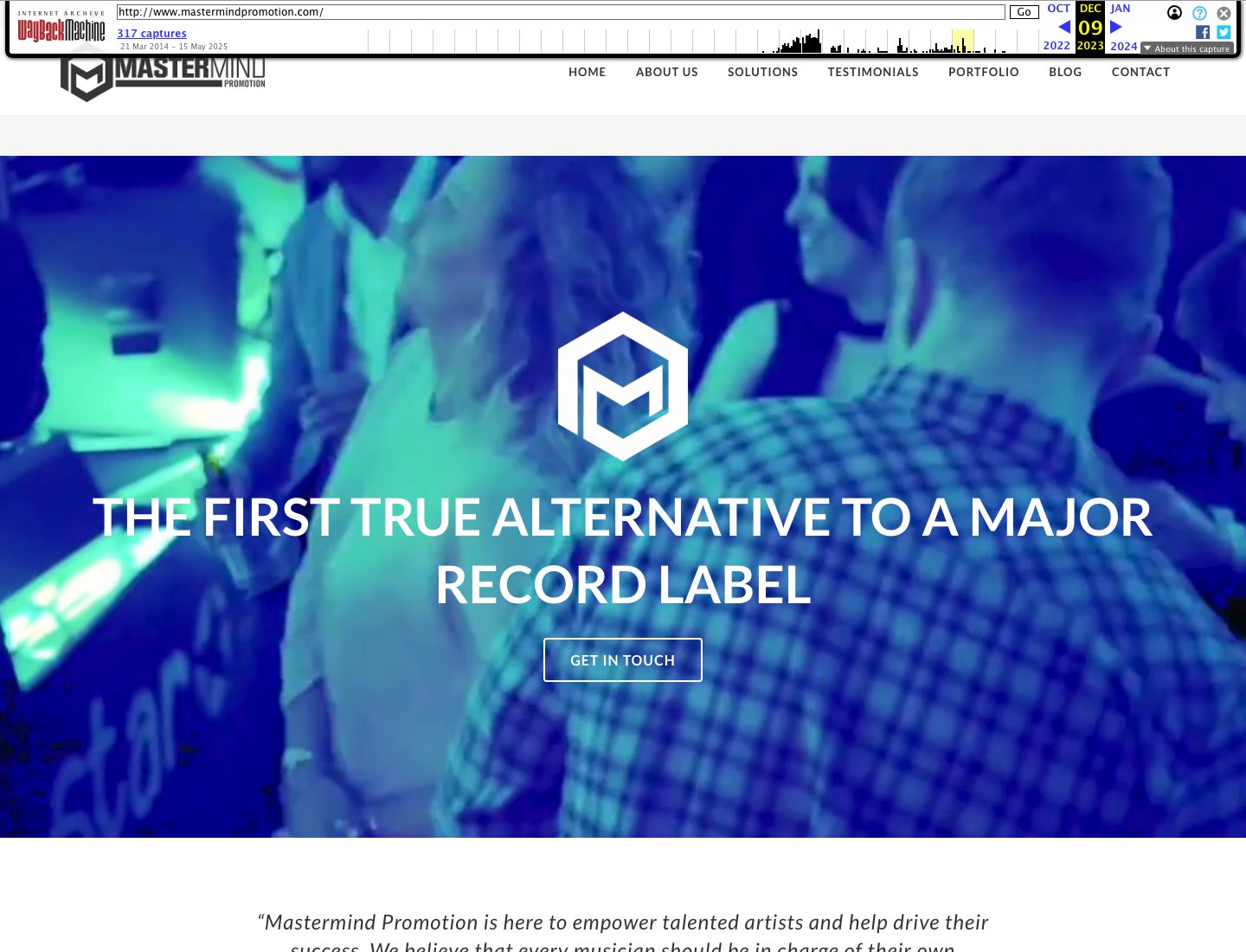 Wayback Machine capture of the Mastermind Promotion home page dated 9 December 2023, a blue-tinted crowd photograph with a white hexagonal M logo and the heading The First True Alternative to a Major Record Label