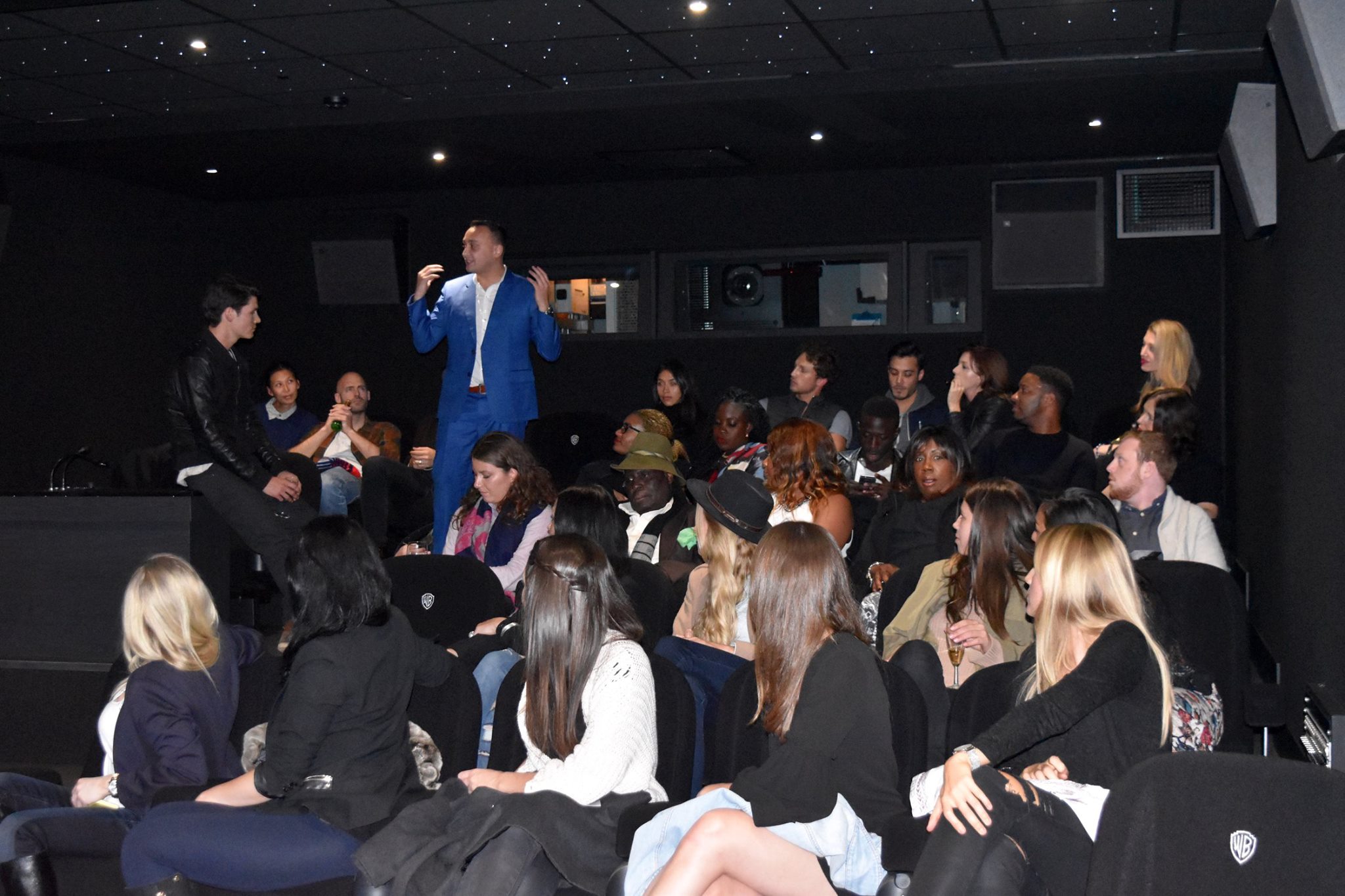 A full screening room at Warner Brothers studio, audience seated, Michael Darius Eastwood addressing the room